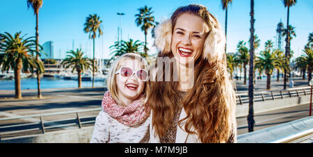 In Barcelona für einen perfekten Winter. Lächeln moderne Mutter und Tochter die Reisenden am Bahndamm in Barcelona, Spanien Stockfoto