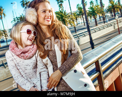 in Barcelona für einen perfekten Winter. glückliche moderne Mutter und Tochter Reisende in Barcelona, Spanien in die Ferne Stockfoto