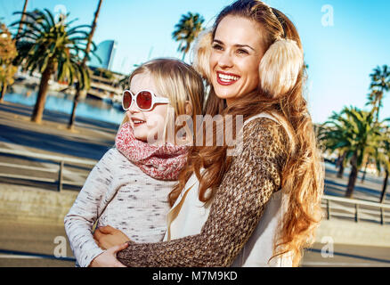 in Barcelona für einen perfekten Winter. glückliche moderne Mutter und Tochter Reisende in Barcelona, Spanien in die Ferne Stockfoto