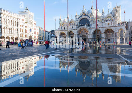 Basilica San Marco und der Uhrturm, Piazza San Marco, dem Markusplatz, in Acqua Alta, oder Flut Hochwasser der Lagune, Venedig, Venet wider Stockfoto