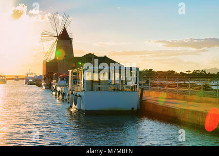 Sonnenuntergang an der Windmühle in das Salz evoporation Teich in Marsala, Sizilien Insel in Italien Stockfoto