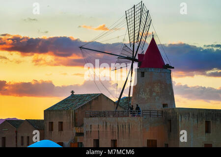 Sonnenuntergang an der Windmühle in das Salz evoporation Teich von Marsala, Sizilien, Italien Stockfoto