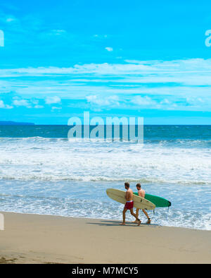 CANGGU, Bali, Indonesien - 19 Jan, 2017: Surfer gehen mit Surfbrett am Strand. Die Insel Bali ist einer der Weltbesten surfen Reiseziele Stockfoto