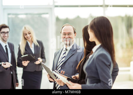 Porträt der erfolgreiche Geschäftsmann auf dem Hintergrund der Business Team und Büro Stockfoto
