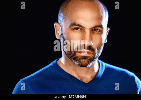 Portrait von Männlichkeit. Portrait von hübscher junger bärtiger Mann mit Kamera, während sich gegen grauer Hintergrund Stockfoto