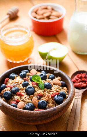 Müsli oder Müsliriegel in Houten mit Blaubeeren, Goji Beeren und Mandeln. Gesunde Lebensweise, gesunde Ernährung, Diät, Vegetarisch, Fitness oder Gewicht Stockfoto