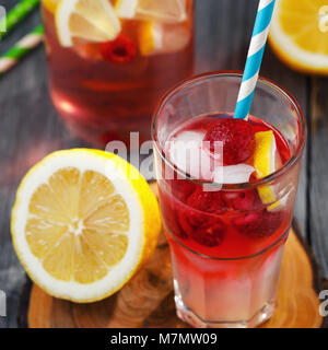 Glas Wasser mit Himbeeren, Zitronenscheiben und Eis Stockfoto