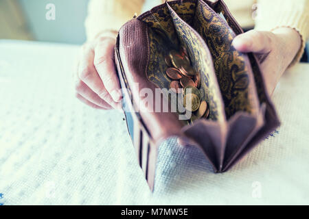 Rentner woman holding in den Händen Geldbörse mit Euro Münzen. Stockfoto
