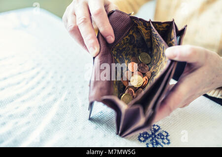 Rentner woman holding in den Händen Geldbörse mit Euro Münzen. Stockfoto