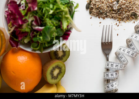 Gesundes Obst, Gemüse und Maßband um die Gabel. Gewicht Verlust und richtige Ernährung Konzept Stockfoto