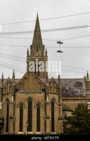 Ein paar Trainer baumelnd von Telefon Kabel durch die Kirche der Heiligen Dreifaltigkeit in Windsor, Großbritannien Stockfoto