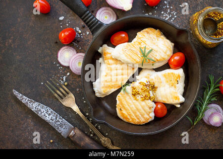 Gegrilltes Hähnchenfilet und verschiedene Gemüse auf einem gusseisernen Pfanne. Kopieren Sie Raum, Ansicht von oben flach Hintergrund. Stockfoto