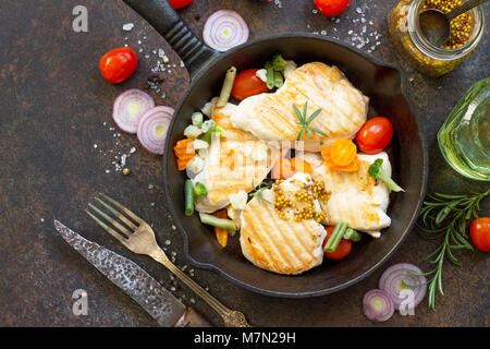 Gegrilltes Hähnchenfilet und verschiedene Gemüse auf einem gusseisernen Pfanne. Kopieren Sie Raum, Ansicht von oben flach Hintergrund. Stockfoto