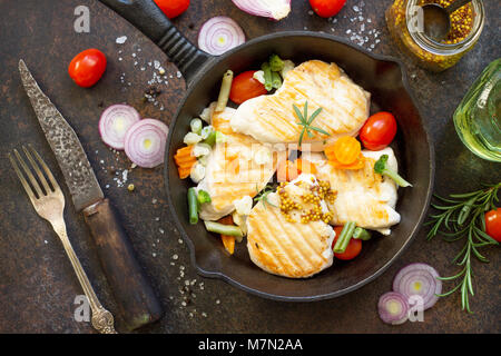 Gegrilltes Hähnchenfilet und verschiedene Gemüse auf einem gusseisernen Pfanne. Kopieren Sie Raum, Ansicht von oben flach Hintergrund. Stockfoto