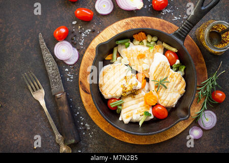 Gegrilltes Hähnchenfilet und verschiedene Gemüse auf einem gusseisernen Pfanne. Kopieren Sie Raum, Ansicht von oben flach Hintergrund. Stockfoto