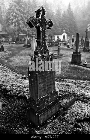 Geheimnisvolle belgischen Friedhof am Waldrand im Winter mit Frost, Eis und Schnee auf den Gräbern Stockfoto