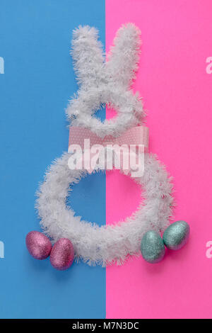Ostern Dekorationen auf helle Farben. Weißer Draht bunny auf Rosa und blauen Hintergrund mit Polka Dot Bow Tie. Stockfoto