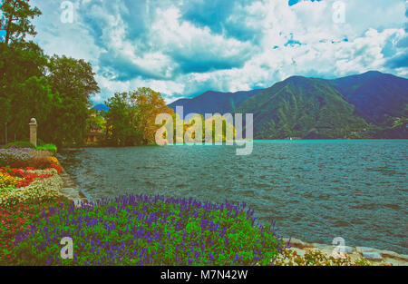 Garten-Park an der Promenade des luxuriösen Resorts von Lugano am Luganer See und Alpen Berge im Kanton Tessin, Schweiz. Stockfoto