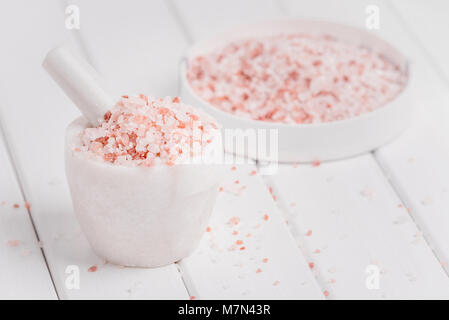 Himalaya Pink salt in weißem Marmor mörser auf Hanf sack Hintergrund. Himalaya-salz häufig in Kochen und für Badewanne Produkte wie Badesalz verwendet. Stockfoto