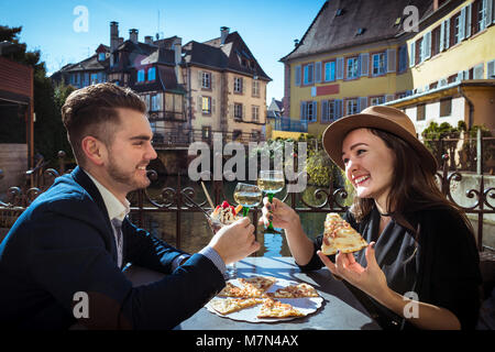 Junge Frau mit Freund Mittagessen im Elsass. Zwei Menschen sitzt zusammen in lokalen Cafe mit Pizza und Wein. Trendige Paar hält Weingläser auf der Terrasse Stockfoto