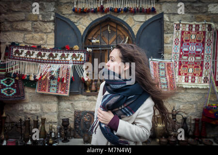 Neugierig erforscht Reisenden authentische orientalische Basar in Zentralasien im Winter. Junge Frau steht in der Nähe von einem schönen Schaukasten auf dem Markt. Stockfoto