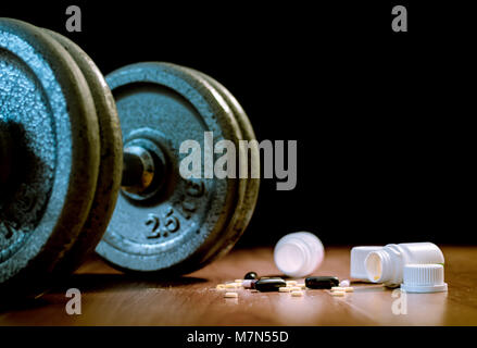 Steroid Pillen und Kapseln mit hantel Gewicht im Hintergrund - Doping im Sport. Stockfoto