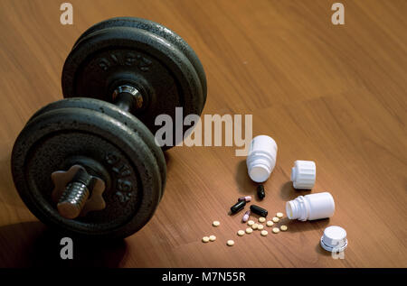 Steroid Pillen und Kapseln mit hantel Gewicht im Hintergrund - Doping im Sport. Stockfoto