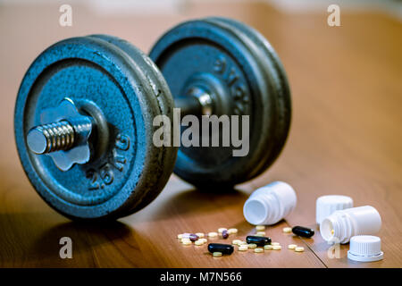 Steroid Pillen und Kapseln mit hantel Gewicht im Hintergrund - Doping im Sport. Stockfoto