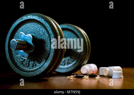 Steroid Pillen und Kapseln mit hantel Gewicht im Hintergrund - Doping im Sport. Stockfoto