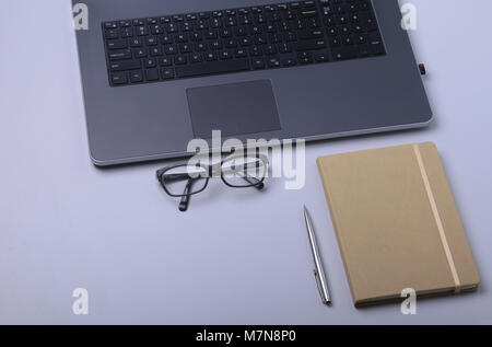 Close-up komfortables Arbeiten im Büro mit Laptop, Notebook, Gläser, Pen und anderen Geräten zur Festlegung auf Tabelle mit Platz kopieren Stockfoto
