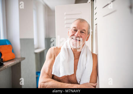 Älterer Mann durch die Schließfächer in ein Hallenbad. Stockfoto