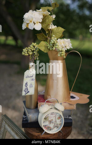 7/8 shot der Details von Alice im Wunderland inspirierte Einrichtung Einrichtung, mit Flasche Schlagwörter mit mir Eisbahn 'd' Meldung, Uhr, Bücher, Blumen und leeren Rahmen Stockfoto