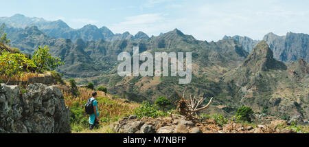 Mann Wanderer wandern in abgelegenen bergigen Landschaft mit landwirtschaftlichen Terrassen in vertikaler Tal Seiten. Santo Antao, Kap Verde Stockfoto