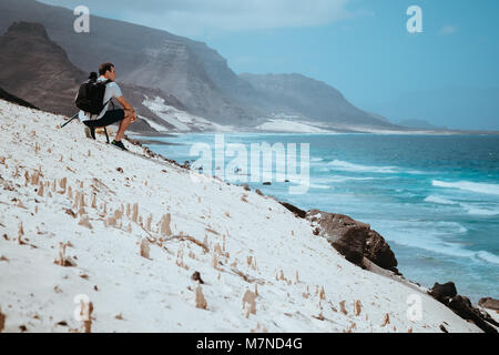 Fotograf mit der Kamera genießen Sie malerische Moment in der malerischen Landschaft der Sanddünen und vulkanischen Klippen. Baia Das Gatas, in der Nähe von Calhau, Insel Sao Vicente Kap Verde Stockfoto