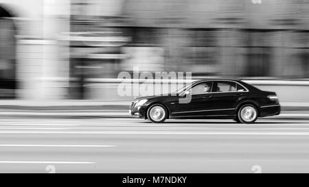 Minsk, Weißrussland - April 15, 2017: Schwarz Mersedes-Benz in Motion bei leerem Independence Avenue. Geschwindigkeit. Motion Blur erschossen. Editorial schwarz-weiß Foto. Stockfoto