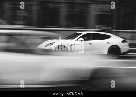 Minsk, Weißrussland - April 15, 2017: Weiße Porsche Panamera in Bewegung bei der intensiven Verkehr auf die Independence Avenue. Geschwindigkeit. Motion Blur erschossen. Editorial Blac Stockfoto