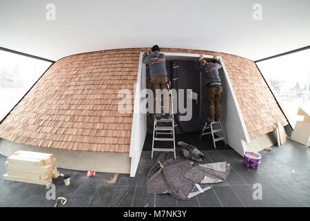 02 März 2018, Deutschland, Holzkirchen: Handwerker legen den letzten Schliff in das Innere der Neubau der katholischen Kirche St. Joseph. Die hölzerne Kirche, deren Form ist auf das Alpenpanorama zu erinnern, ist eine der beiden neuen Kirchen, die in Bavara dieses jahr geweiht werden sollte. Die Weihe wird am 18. März 2018 stattfinden. Foto: Andreas Gebert/dpa Stockfoto