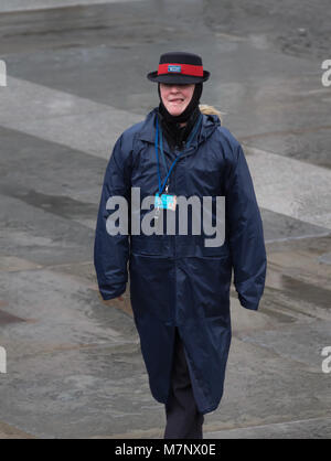 Piccadilly Circus, London, UK. 12 Mär, 2018. Erbe warden trägt eine wasserdichte Jacke an trüben, nassen und miserablen Tag in London. Schwere Unwetter sind in der ganzen Woche über den größten Teil des Landes, mit dem Met Office Warnung vor unsicheren Bedingungen erwartet und sogar die Möglichkeit von Gewittern Credit: Keith Larby/Alamy leben Nachrichten Stockfoto