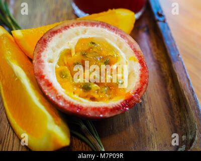 Passionsfrucht und Orange Slice in hölzerne Platte Stockfoto