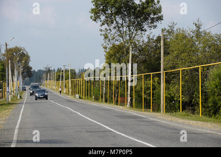 Oberirdische Erdgasleitungen, gelb lackiert und während der sowjetischen Zeit installiert, führen neben einer Straße durch Kheta, Georgien Stockfoto