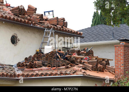 Viele Steine auf dem Dach eines Hauses angehäuft, Prozess der Entfernen mehrerer Layer von einem Ziegeldach. Ton-ziegel wiegt in der Regel mehr als Beton, überall Stockfoto