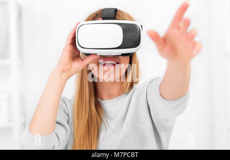 Virtual reality Brillen. Eine attraktive junge Frau mit Virtual reality Brillen in einem hellen Raum. Stockfoto