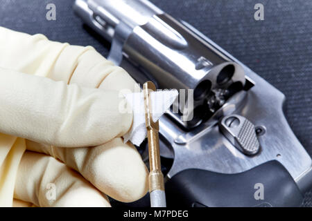 Snubnose Revolver mit Zylinder öffnen in Vorbereitung, mit dem eine Hand einfügen einer Baumwolle Patch in die Pistole Reinigungsstab auf Schwarz Matte isoliert, gereinigt werden müssen Stockfoto