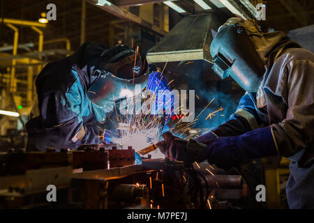 Team Arbeiter schweißen Teil im Werk Stockfoto