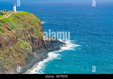 Ein alter Leuchtturm mit einem roten Dach auf einem entfernten Felsen über einem ruhigen Ozean in der Hawaii Inseln bei Tageslicht. Konzept für die Einsamkeit und die Einsamkeit Stockfoto