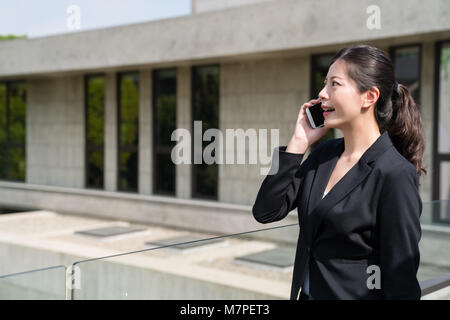 Porträt einer Geschäftsfrau im Amt formelle Kleidung im Gespräch mit dem Kunden über das Mobiltelefon außerhalb. Stockfoto