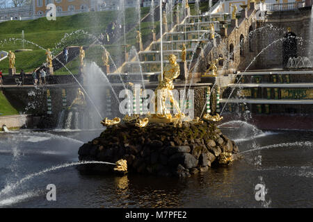 Peterhof, St. Petersburg, Russland - 7. Mai 2016: Touristen zu Fuß rund um den Kanal und die Große Kaskade gegen Grand Palace. Die Kaskade wurde Buil Stockfoto