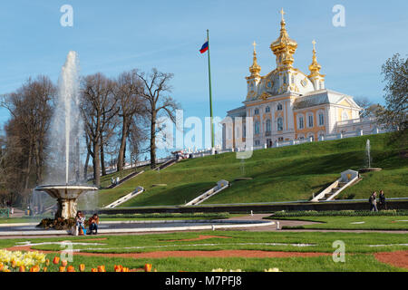 Peterhof, St. Petersburg, Russland - 7. Mai 2016: Touristen wandern und Erholung in der Nähe der Französischen Brunnen gegen Grand Palace. Der Palast wurde im 17 gebaut Stockfoto