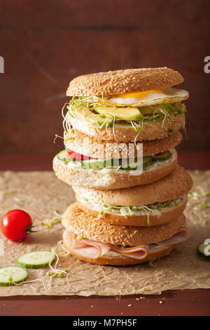 Auswahl an Sandwiches auf Bagels: Ei, Avocado, Schinken, Tomate, Weichkäse, Alfalfa Sprossen Stockfoto