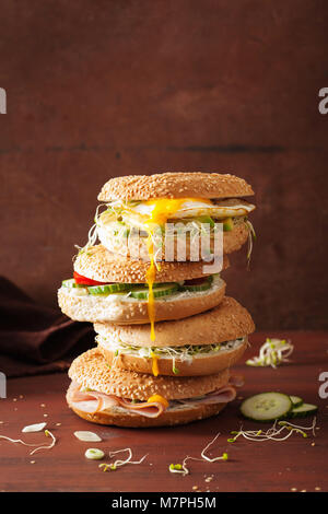 Auswahl an Sandwiches auf Bagels: Ei, Avocado, Schinken, Tomate, Weichkäse, Alfalfa Sprossen Stockfoto